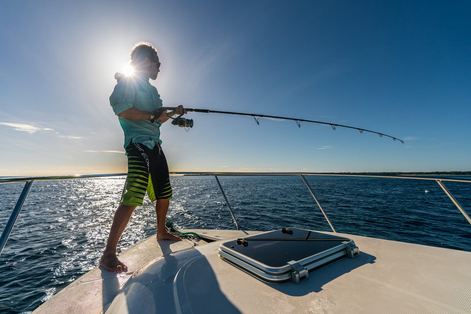 A guest standing on the boat deep sea fishing with Miavana by Time + Tide, Madagascar