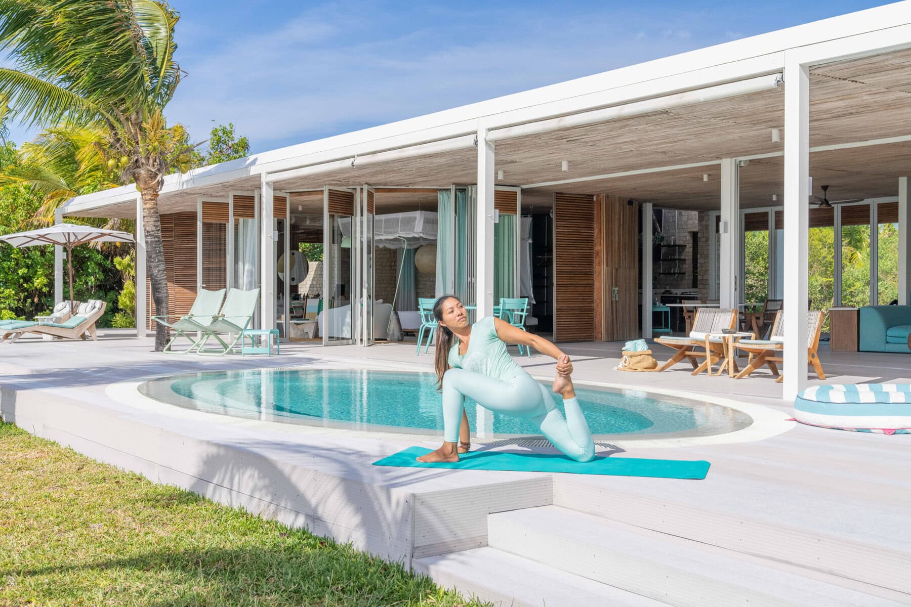 A woman striking a yoga pose on the private deck of a villa at Miavana by Time + Tide in Madagascar