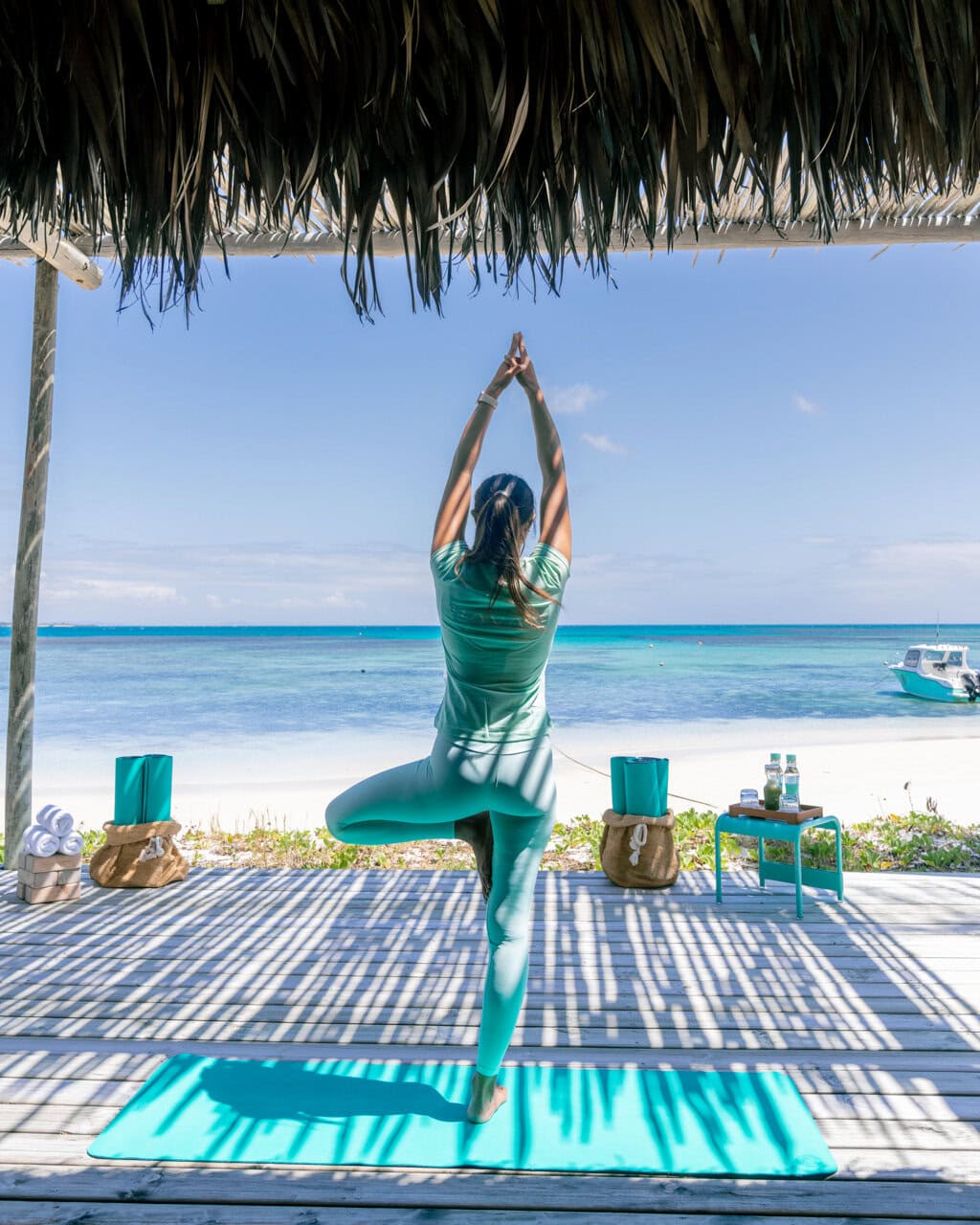 A woman striking a yoga pose on the yoga deck at Miavana by Time + Tide in Madagascar