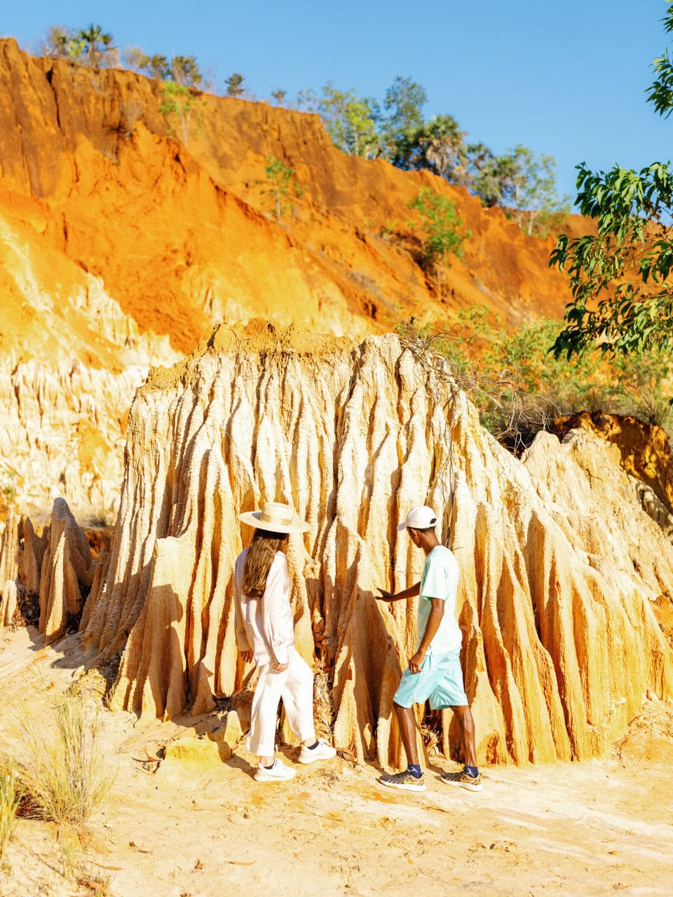 A guide pointing to the tsingy rouge rock formations to a guest on an excursion with Miavana by Time + Tide Madagascar