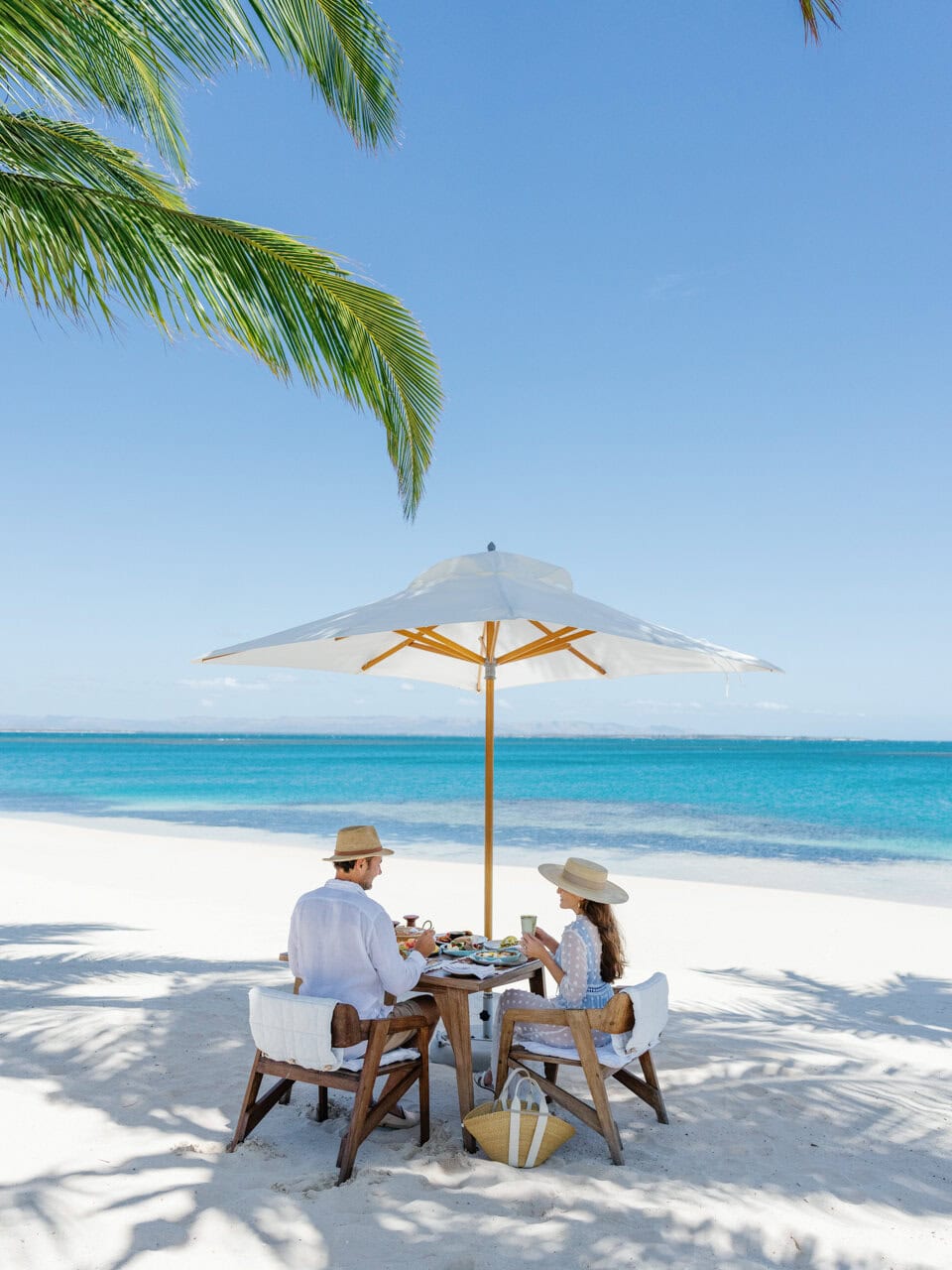 A couple eating breakfast on the beach at Miavana by Time + Tide in Madagascar the best private island resort in the world
